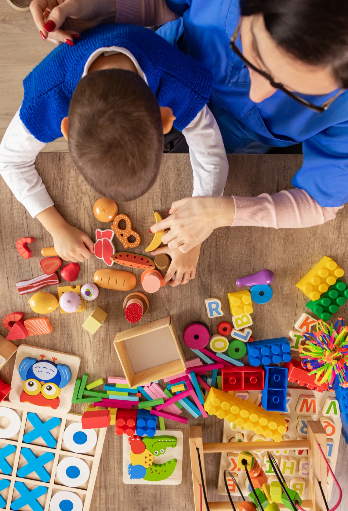 Child and adult playing with educational toys.