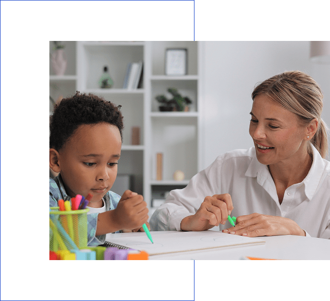 A teacher helping a young student with drawing or writing.