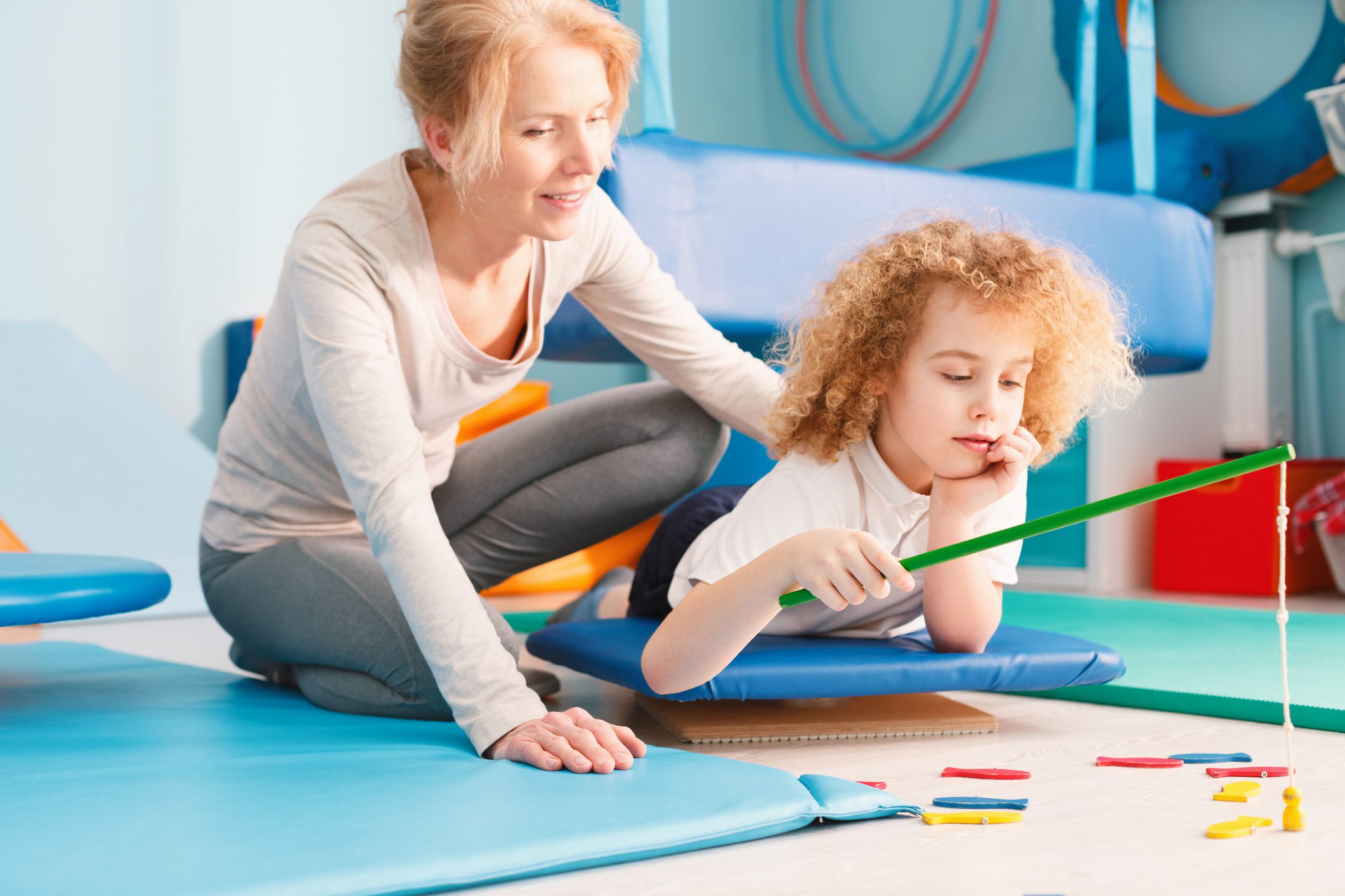 Mother helping daughter with drawing at home.